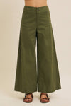 Green wide-leg pants worn by a person on a beige background
