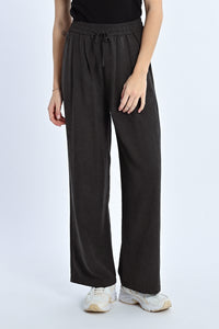 Person wearing black wide-leg pants on a white background