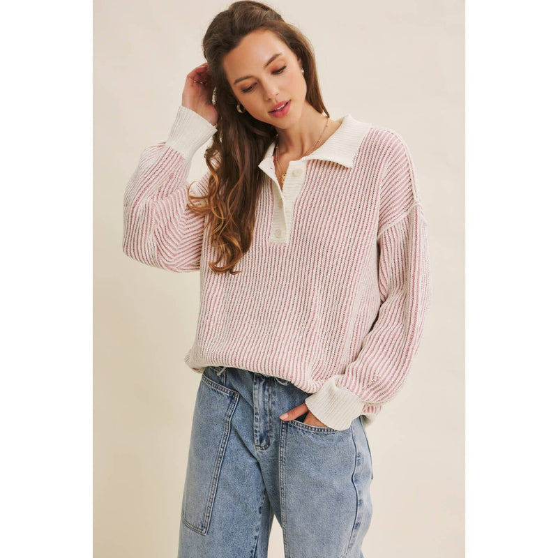 Woman wearing a striped shirt and jeans against a plain background
